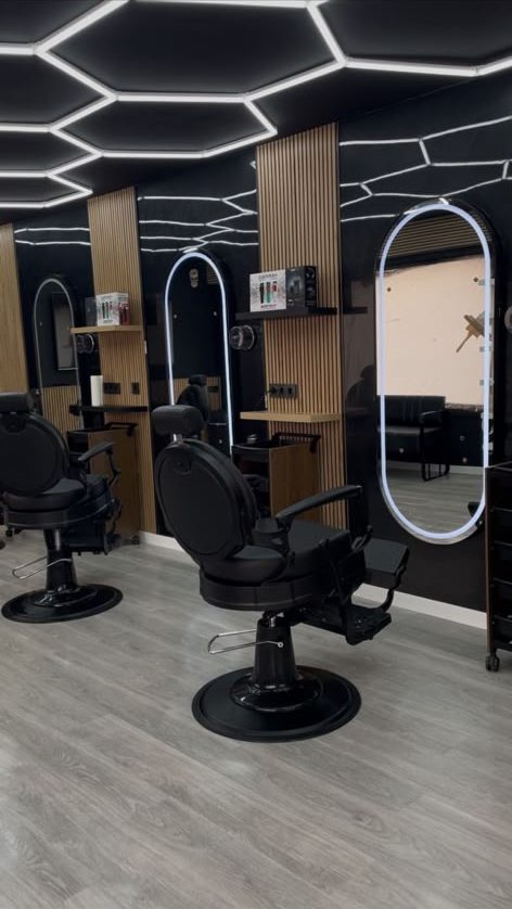 Sillones de barbero frente a los espejos iluminados